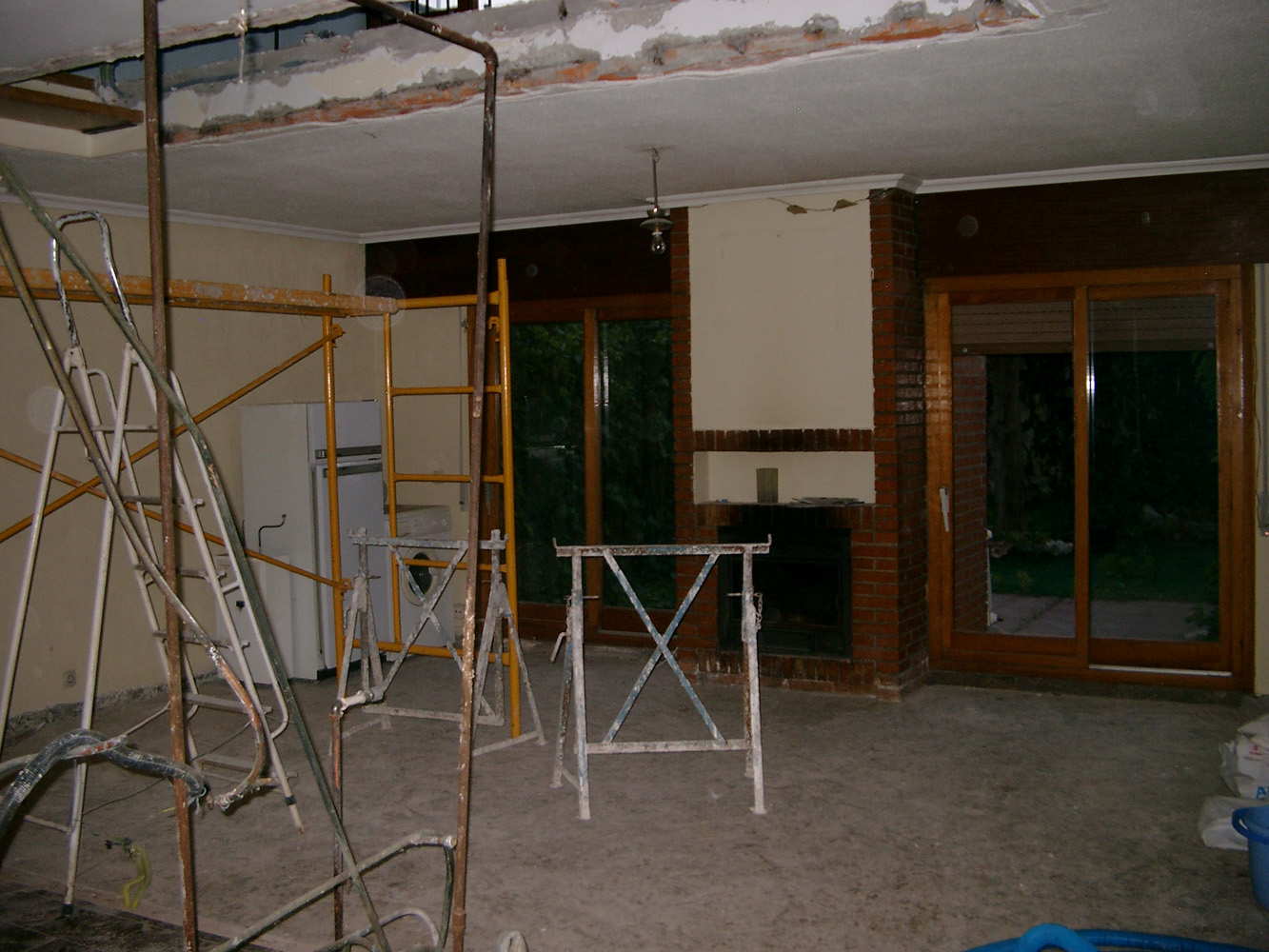 Espacio del salón tras la demolición de la tabiquería previo a la reforma,cubrición del tendedero y cierre del paso entre garaje y vivienda